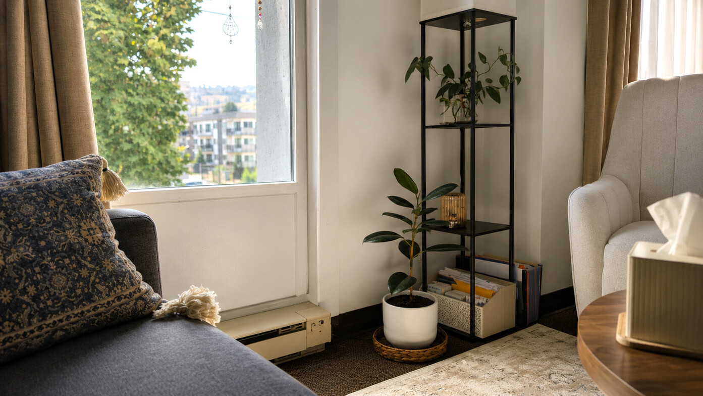 Counselling room at Alicia Norman Counselling in Kamloops, with an empty client chair, couch, plants, and natural light.